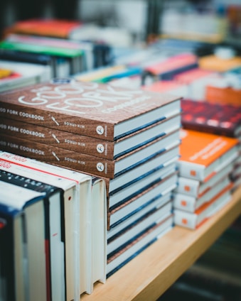 brown and white books on brown wooden shelf