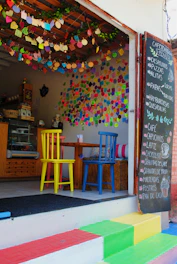 A friendly local cafe bustling with customers and colorful signage.