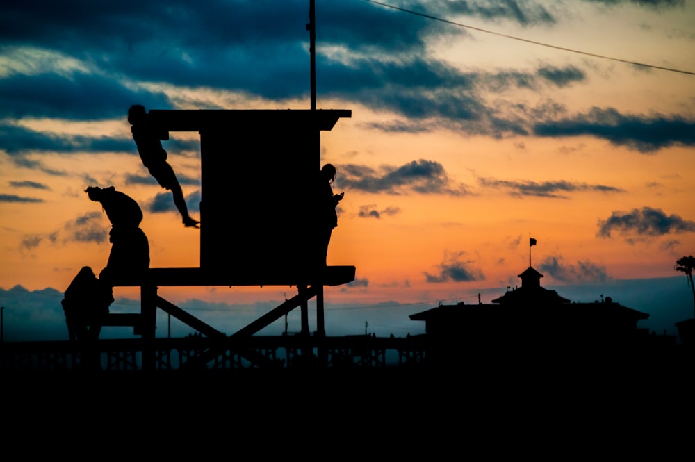 silhouette of man sitting on chair during sunset