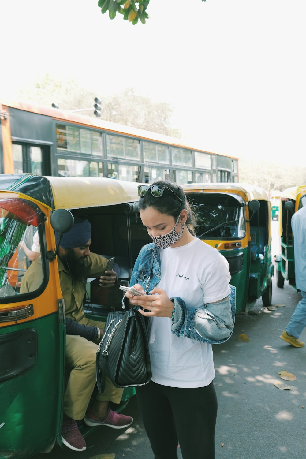Frau im weißen Langarmhemd steht tagsüber neben dem grünen Bus