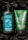 Two Bath & Body Works aromatherapy products featuring stress relief properties are placed against a dark background. The left product is a green bottle of moisturizing body lotion infused with eucalyptus and tea, adorned with water droplets. On the right is a green tube of invigorating body scrub with eucalyptus and spearmint. Both products are surrounded by pieces of black charcoal.