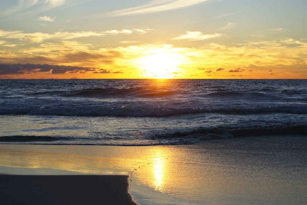 sea waves crashing on shore during sunset