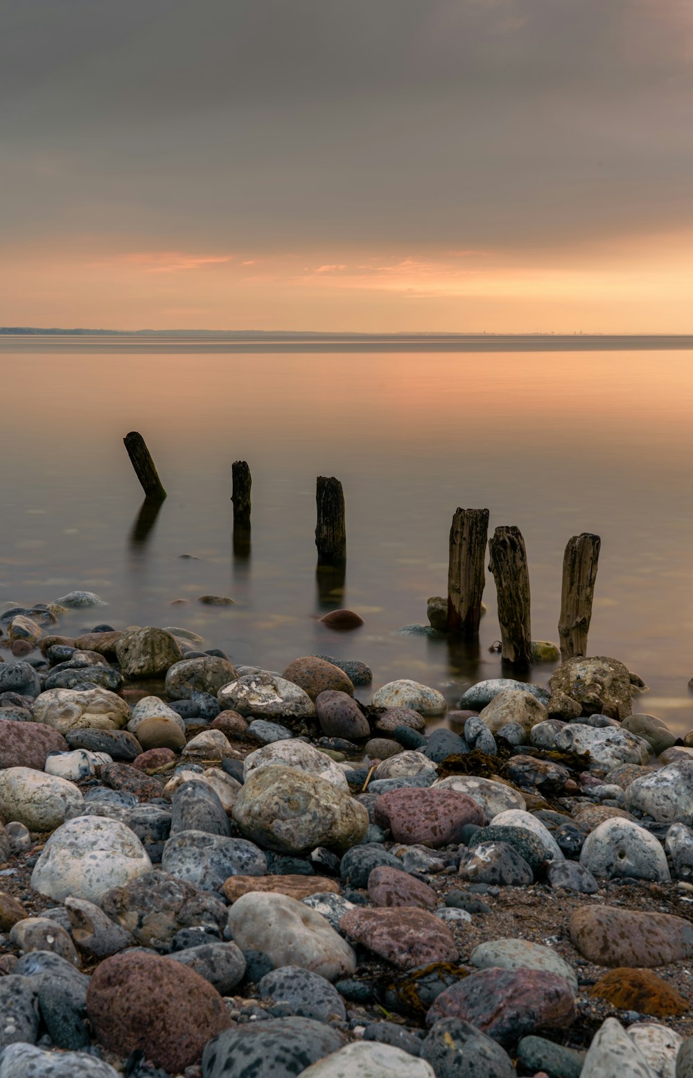 brown and gray rocks on sea shore during sunset