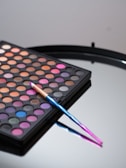 A makeup palette with vibrant colors laid out on a clean white surface.