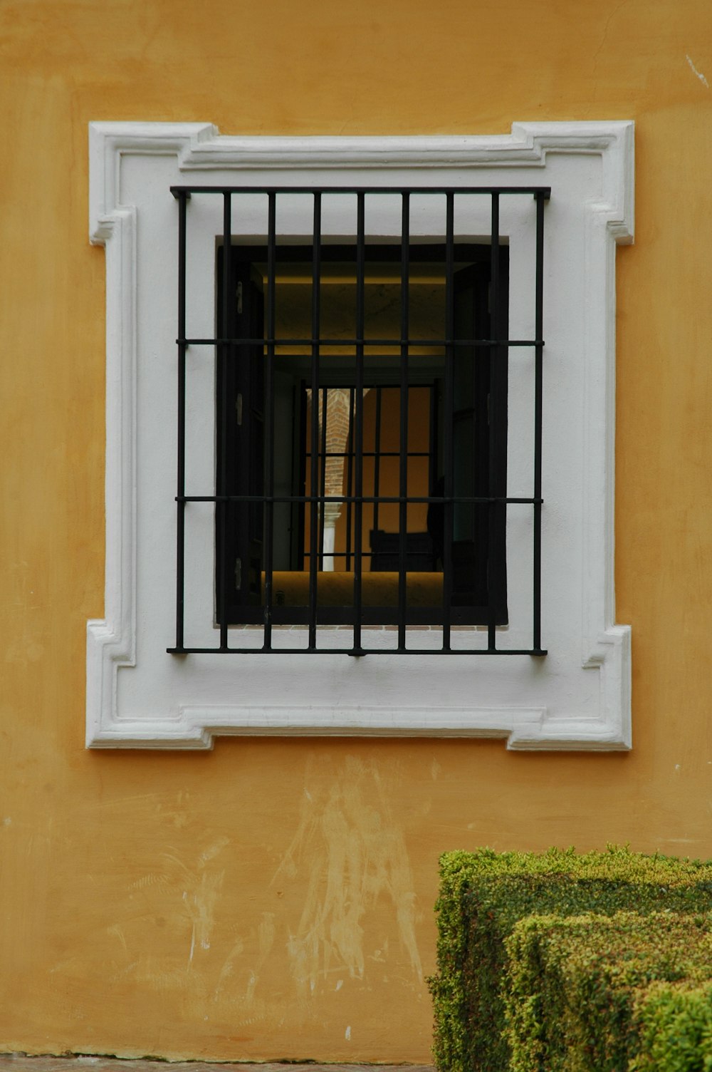 茶色のコンクリートの壁に黒い金属製の窓のグリル