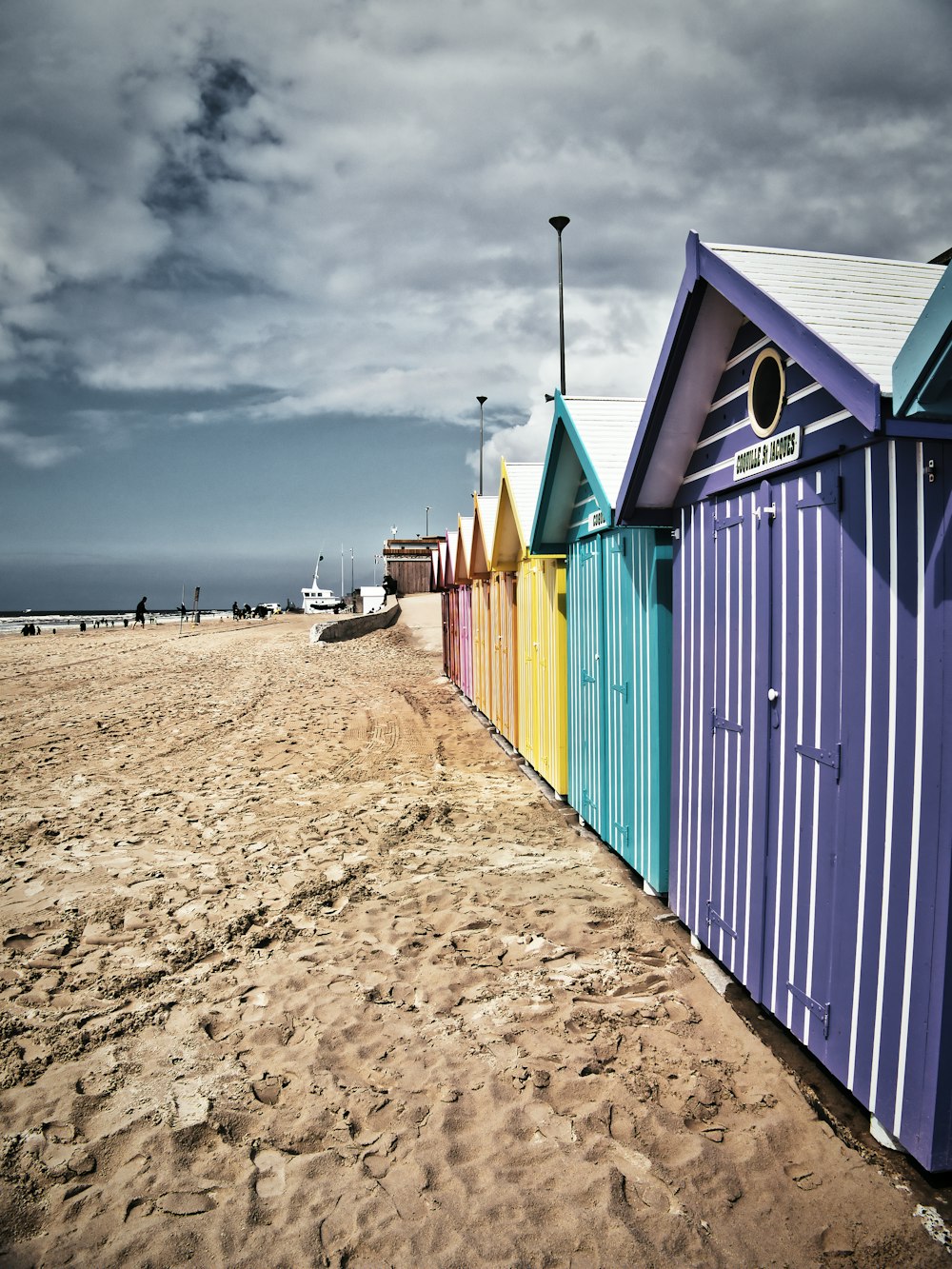 blue and green wooden houses on beach during daytime