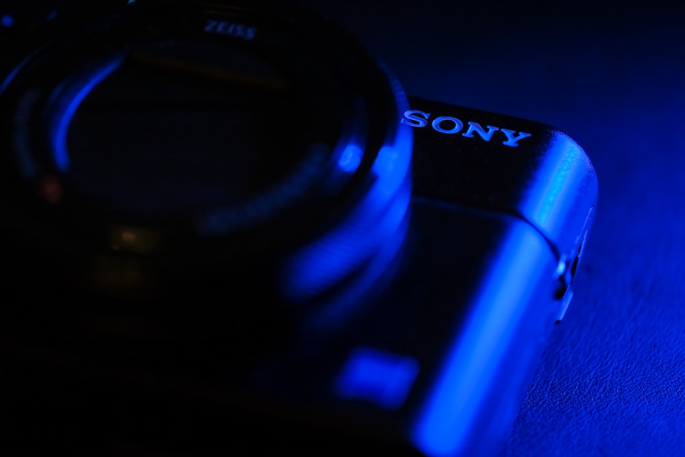 black sony camera lens on blue surface