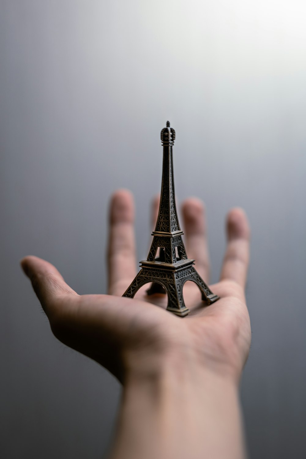 person holding eiffel tower miniature