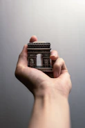 Close-up of hands holding a model of Reunion Island with notes and sketches in the background.