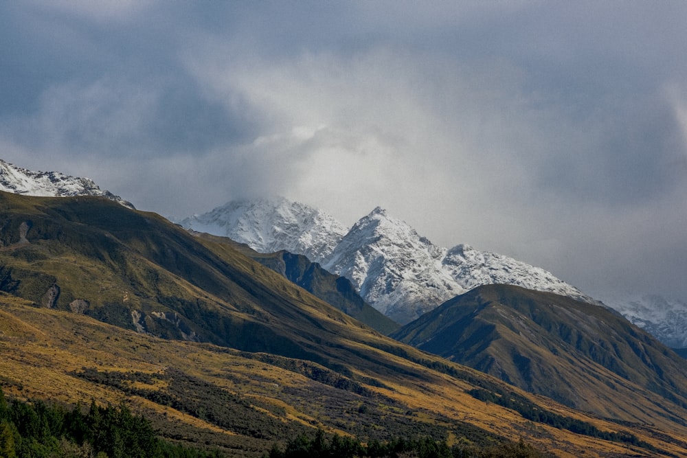 snow covered mountains under cloudy sky during daytime