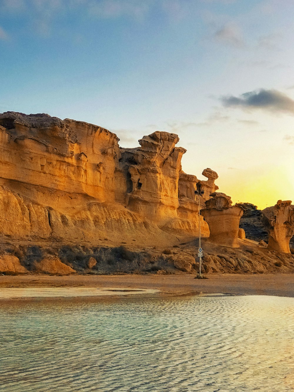 brown rock formation on body of water during daytime