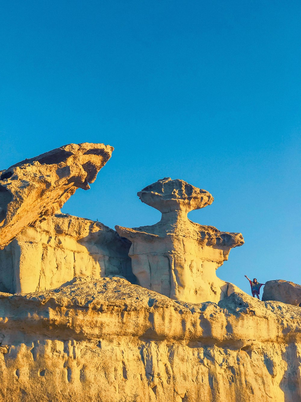 people on top of brown rock formation during daytime