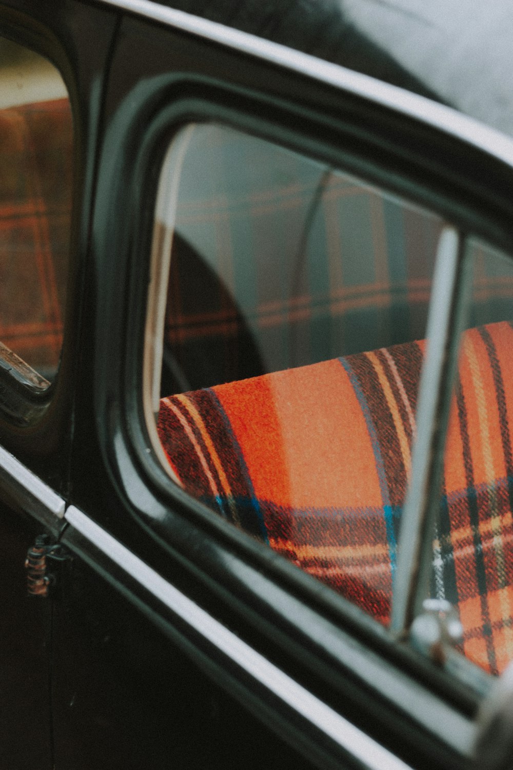 black car side mirror with blue and white plaid textile