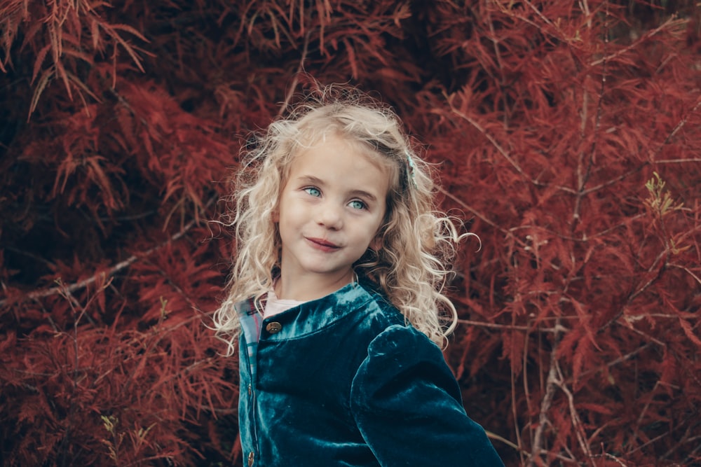 girl in blue denim jacket standing on red leaves