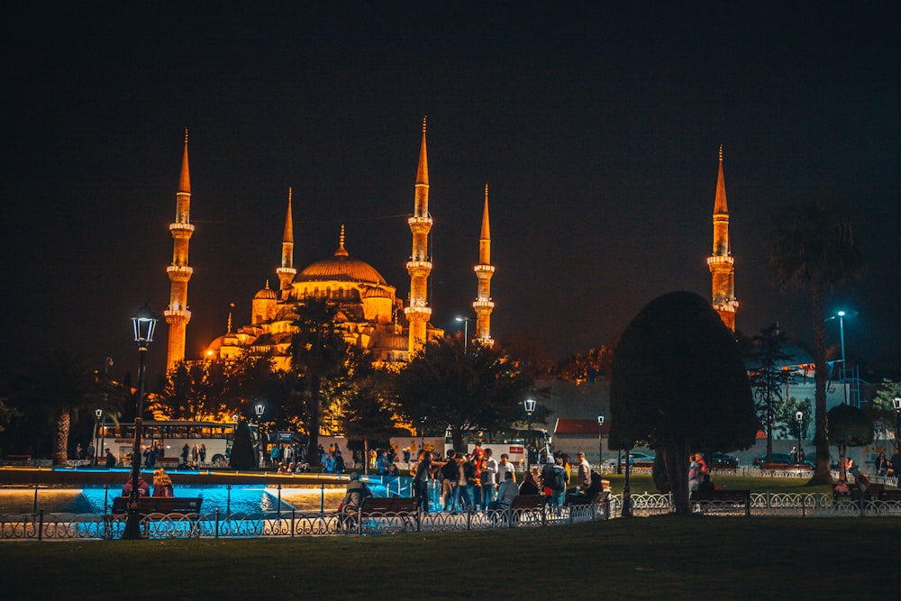 people walking on street near white concrete building during nighttime