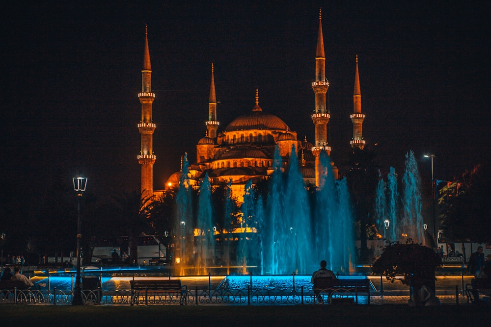 people in front of white concrete building during night time