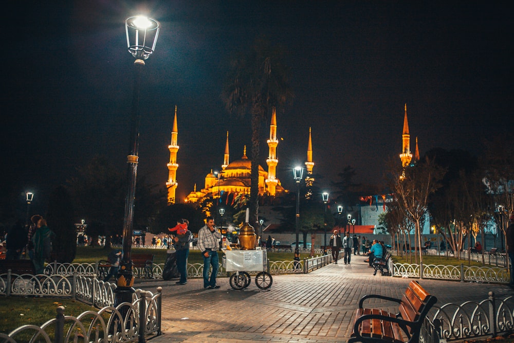 people sitting on bench near mosque during night time