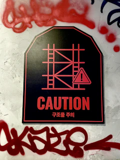 Brightly colored caution and warning signs displayed on a factory wall.