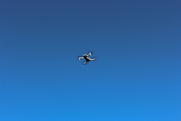 A close-up of a cutting-edge American military drone soaring against a clear blue sky.