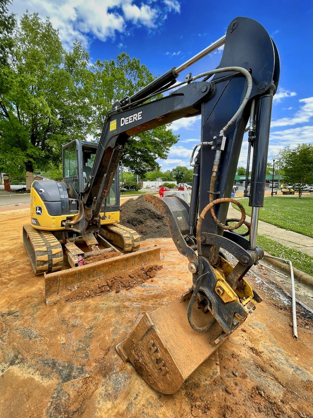 yellow and black excavator on brown dirt road during daytime