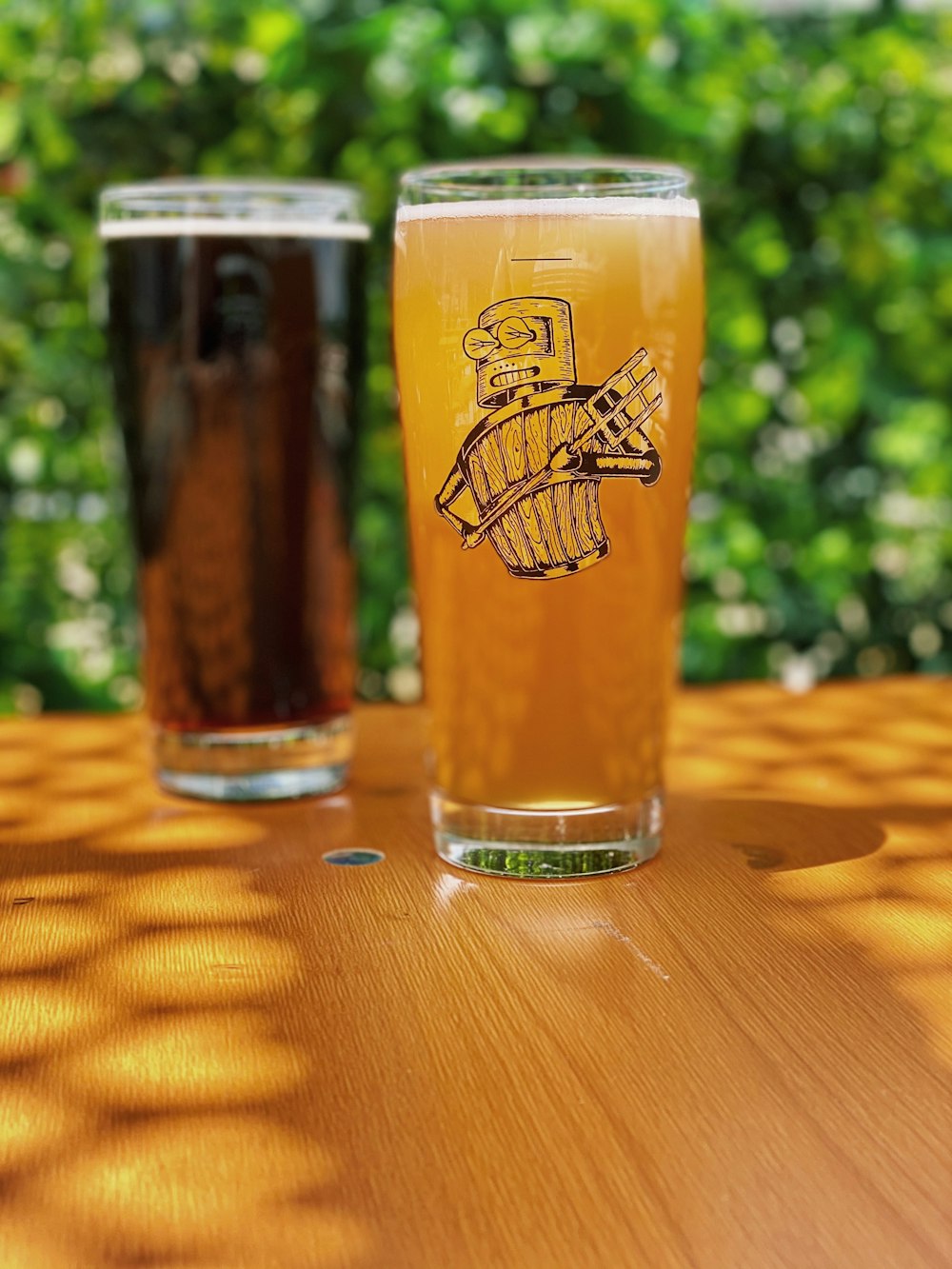 clear drinking glass with beer on brown wooden table