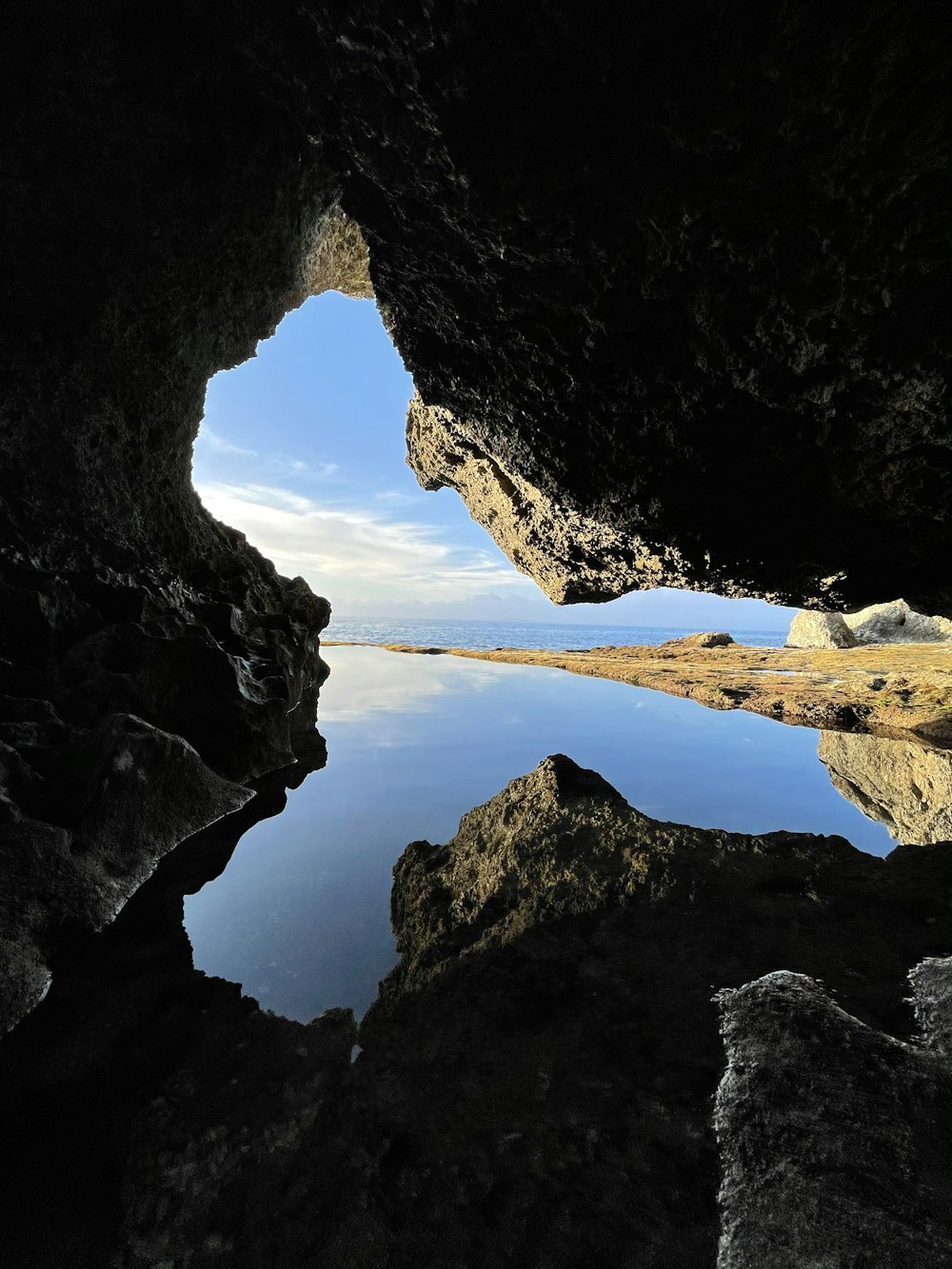 black rock formation near body of water during daytime