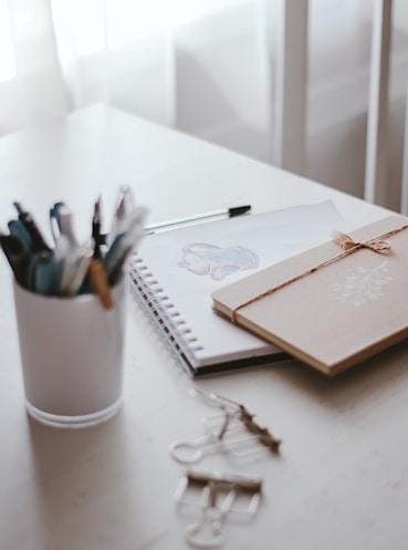 pens and scissors on white ceramic mug