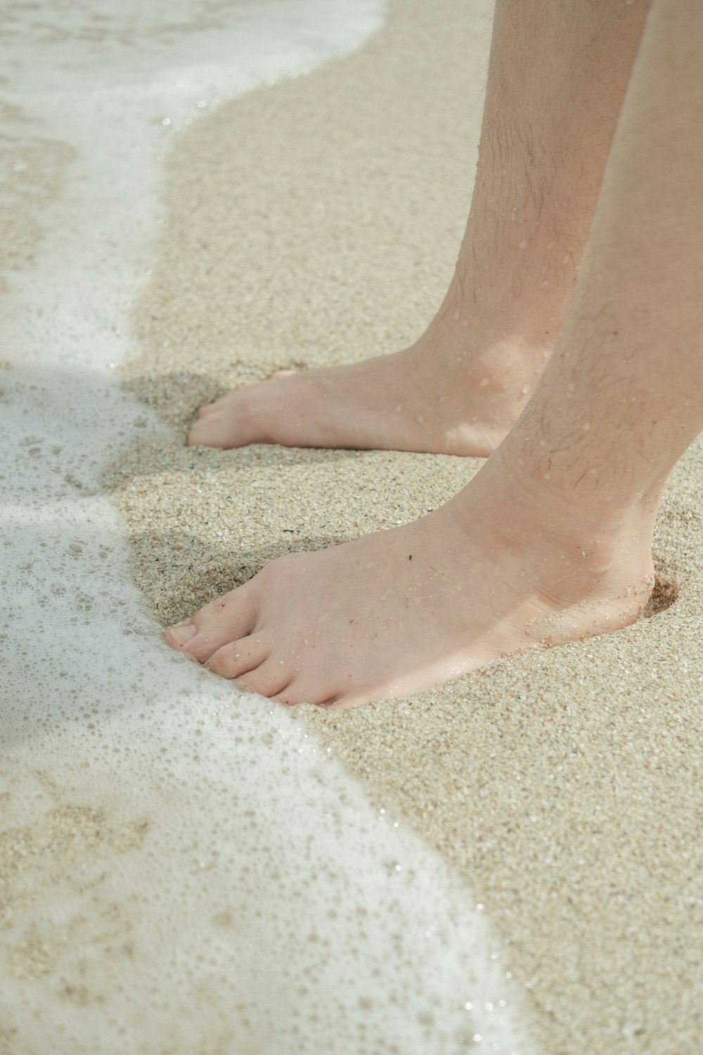 Persona in piedi sulla sabbia bianca durante il giorno