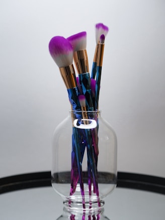 makeup brushes in clear glass container