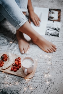 A cozy indoor scene with feet in comfy saturnshoes resting on a soft rug near a warm cup of coffee.