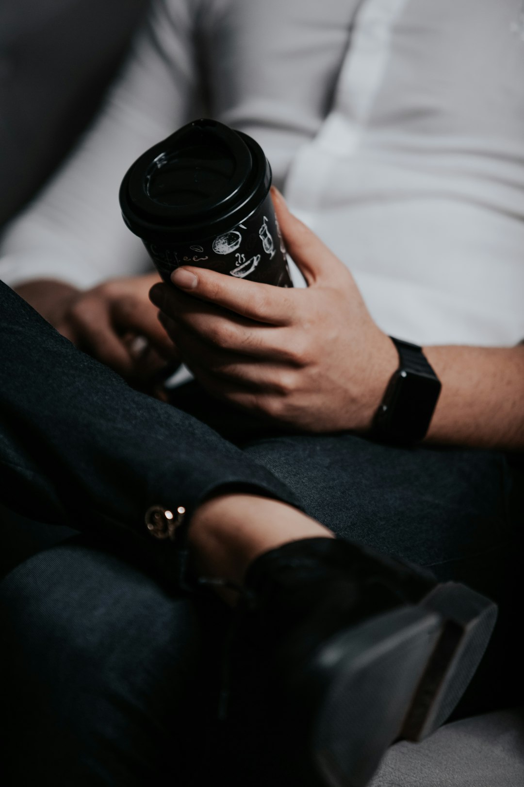 person holding black and white disposable cup