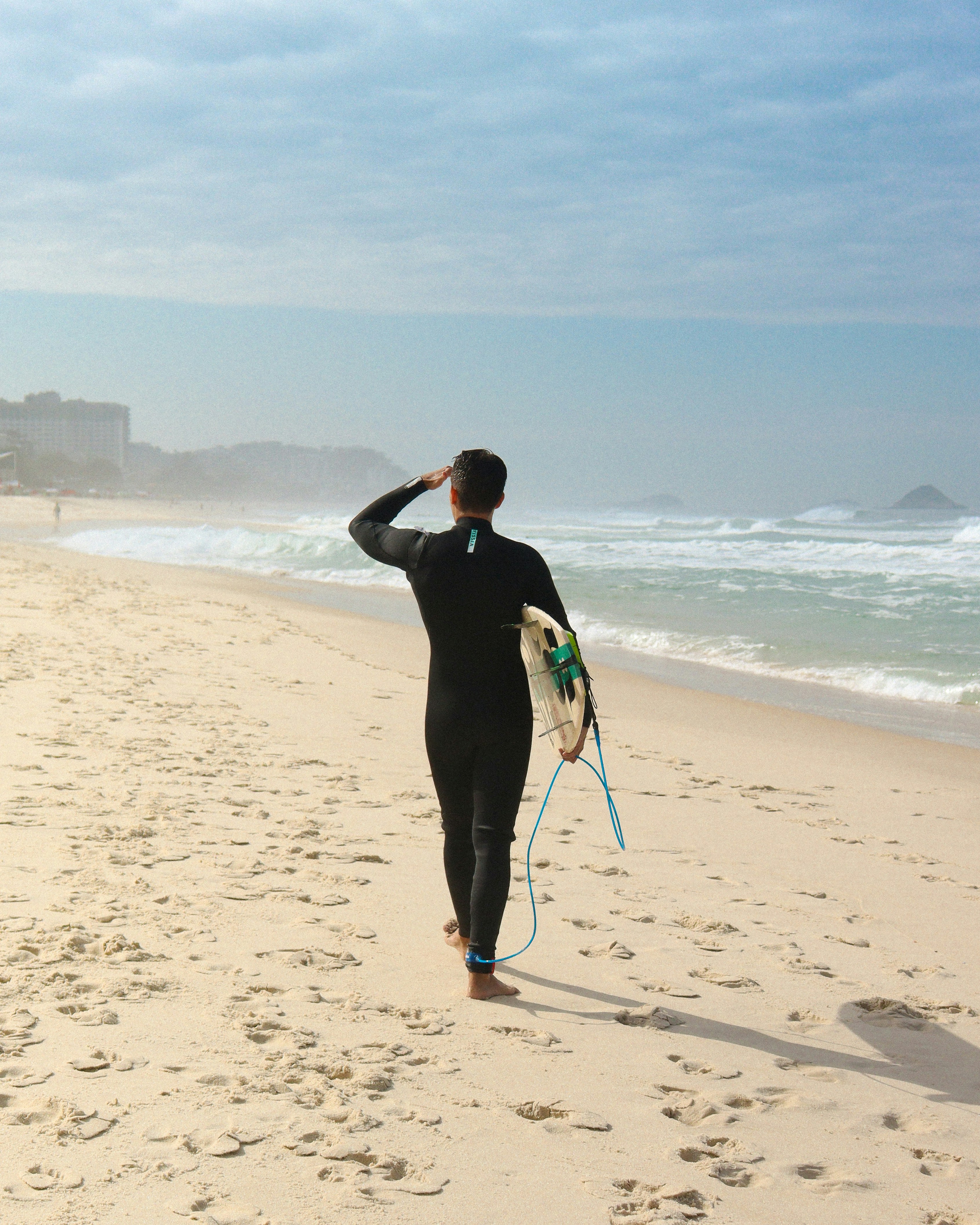 man in black jacket walking on beach during daytime