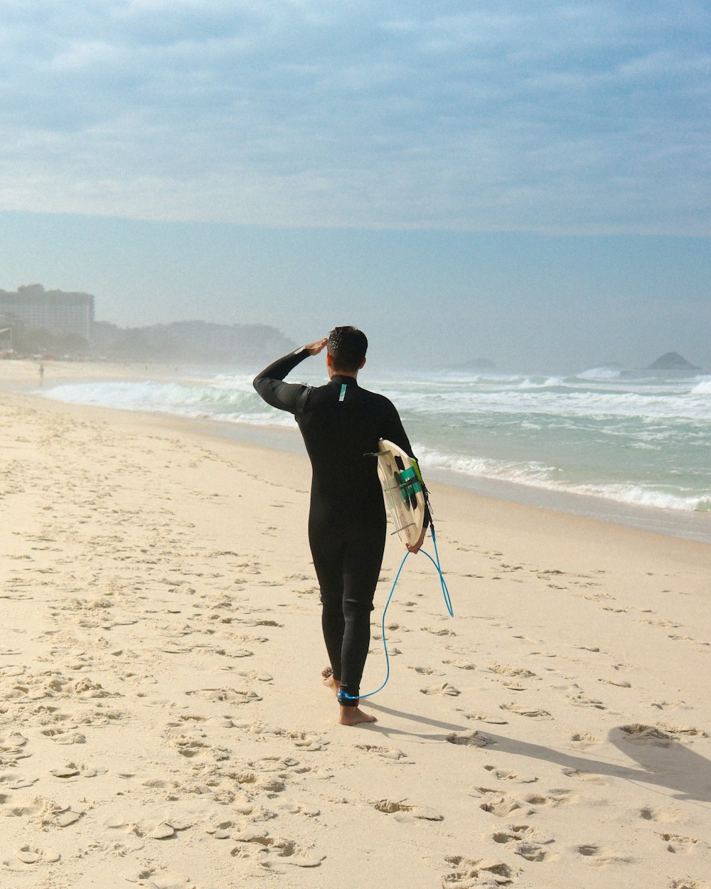 homem na jaqueta preta que anda na praia durante o dia