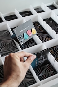 Close-up of vibrant music trivia cards spread out with hands reaching in to pick one.