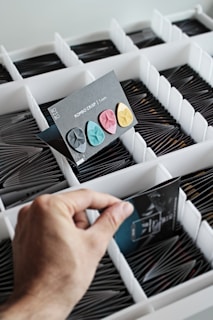 Close-up of vibrant music trivia cards spread out with hands reaching in to pick one.