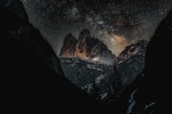 A stunning view of a starry night sky over mountains.