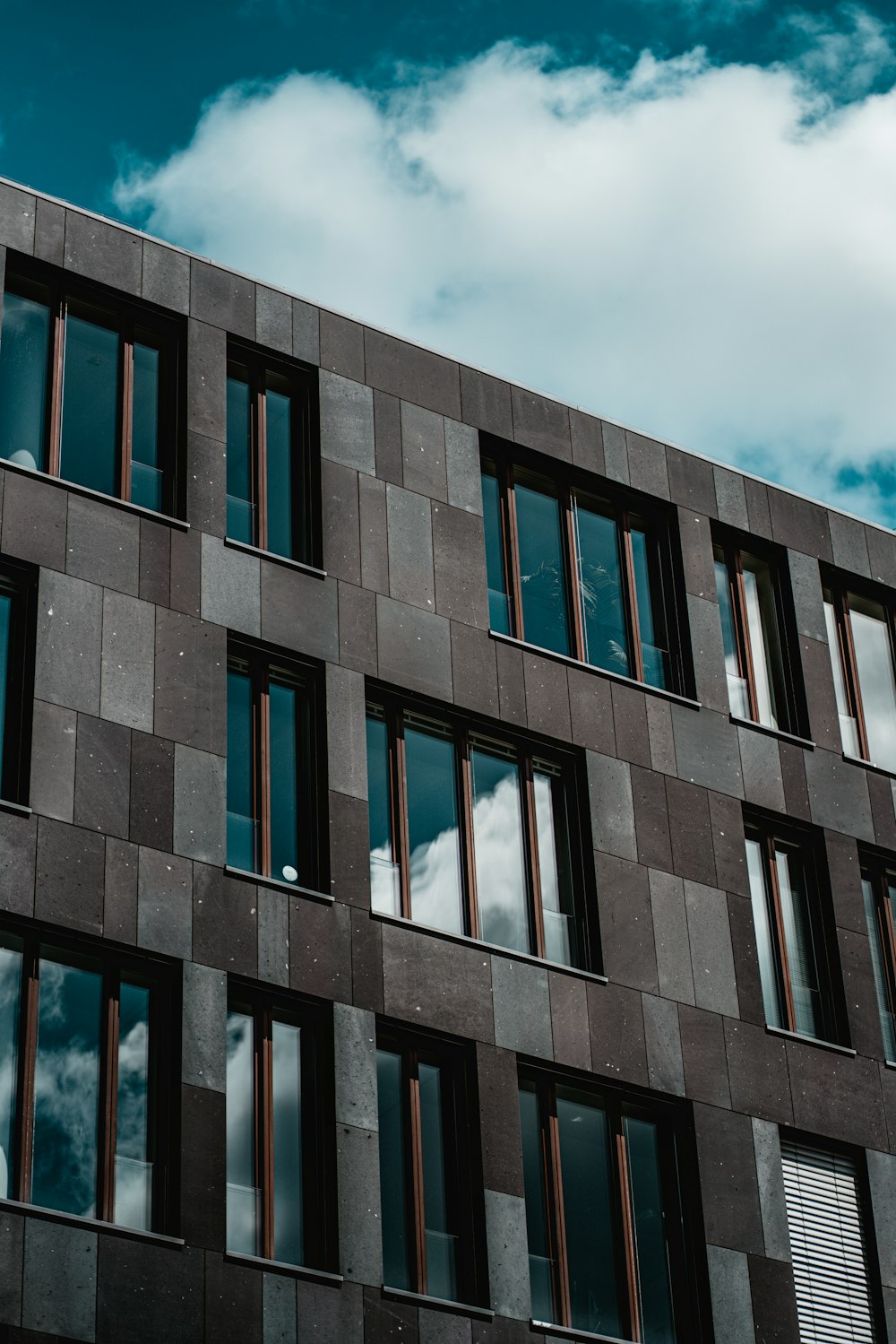 Blaues Betongebäude unter weißen Wolken tagsüber