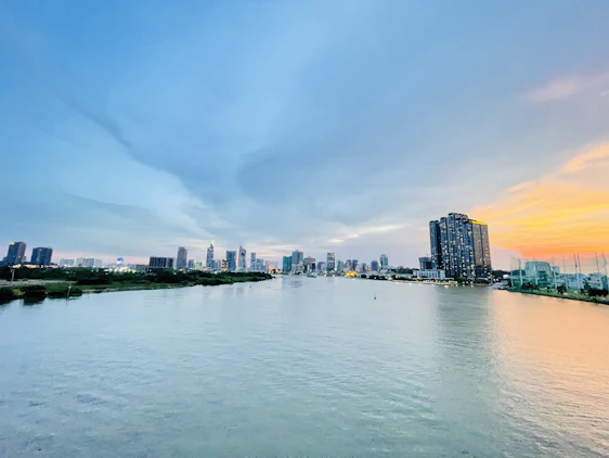 A panoramic view of the Nile River with modern Egyptian homes along its banks at sunset.