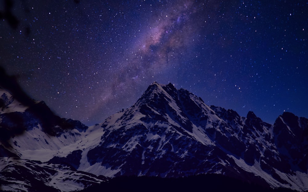 Montaña cubierta de nieve bajo la noche estrellada