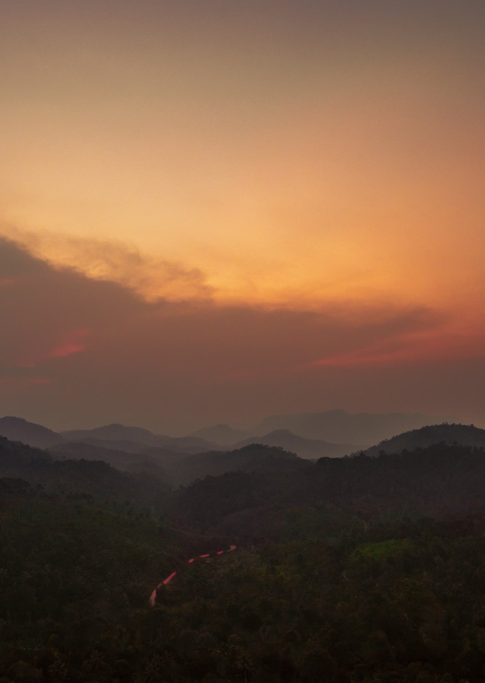 green mountains under orange sky