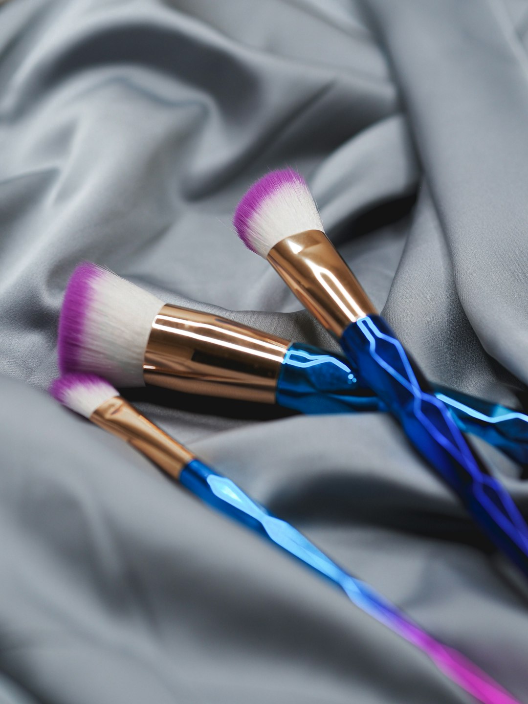 blue and brown makeup brush on white textile