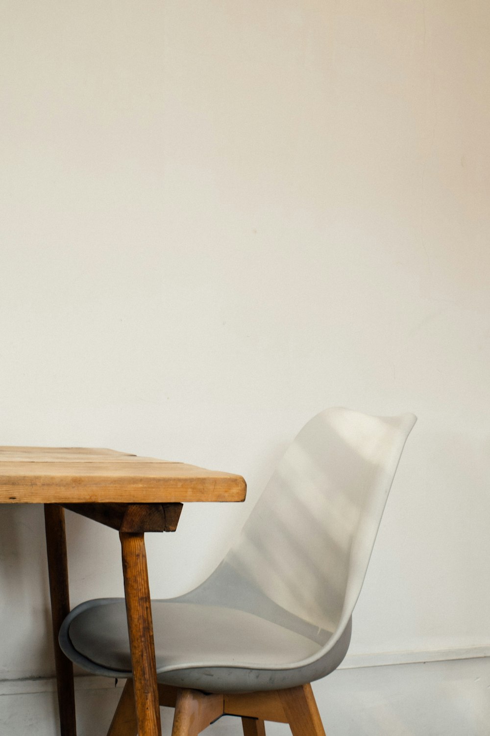 Chaise en plastique blanc à côté d’une table en bois marron