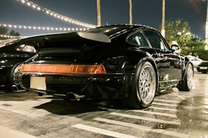 An elegant gathering under glowing ambient lights with cars parked in a neat row.