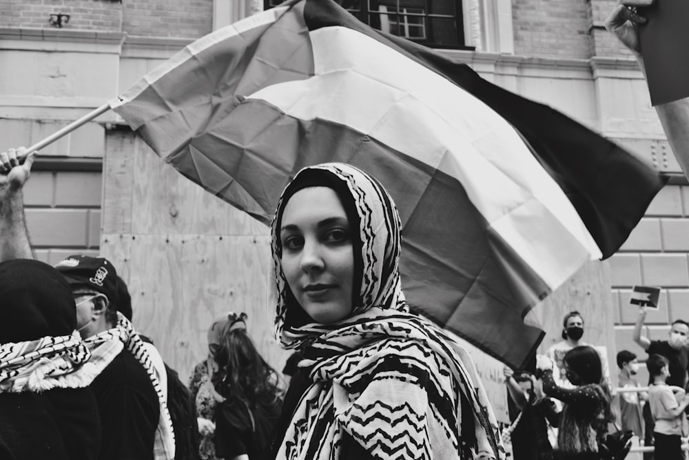 Frau im weißen Hijab steht tagsüber in der Nähe von Menschen
