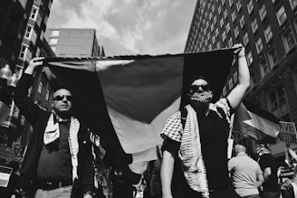 grayscale photo of people holding flags