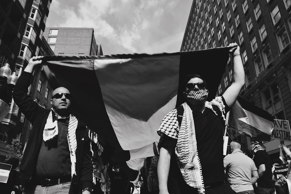 grayscale photo of people holding flags