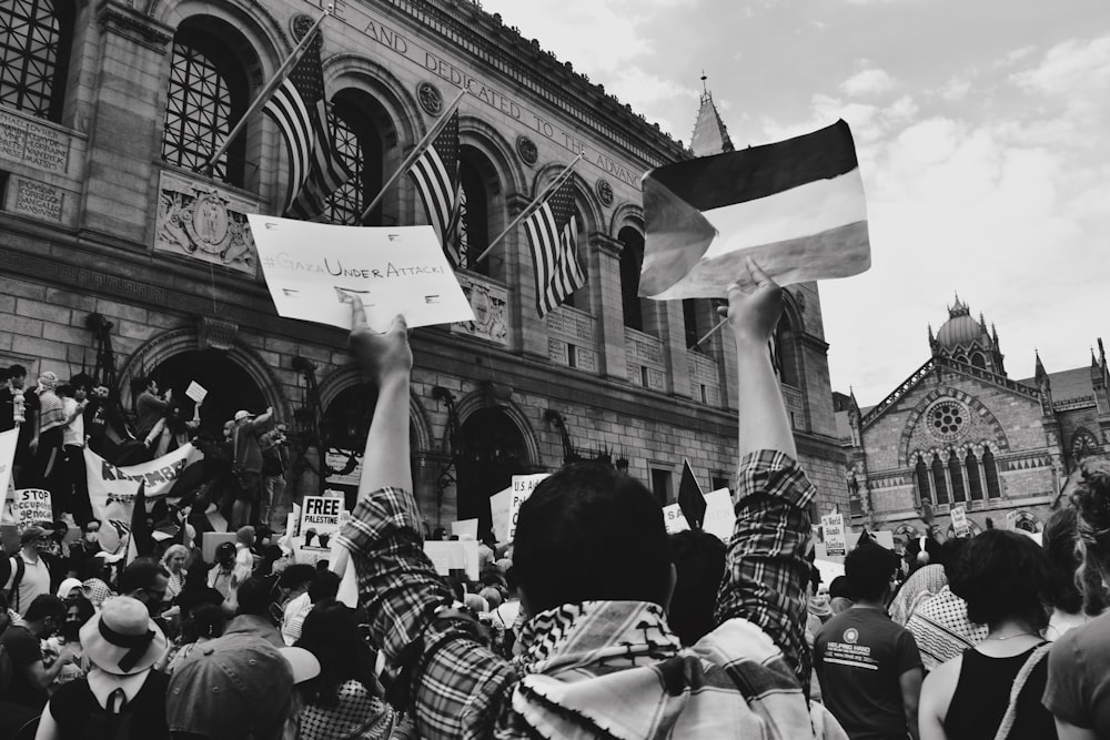 Foto en escala de grises de personas frente al edificio