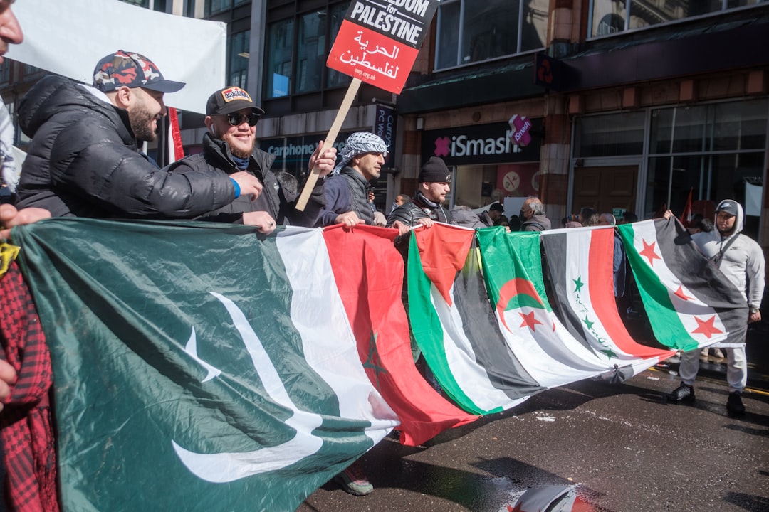 man in black jacket holding green flag