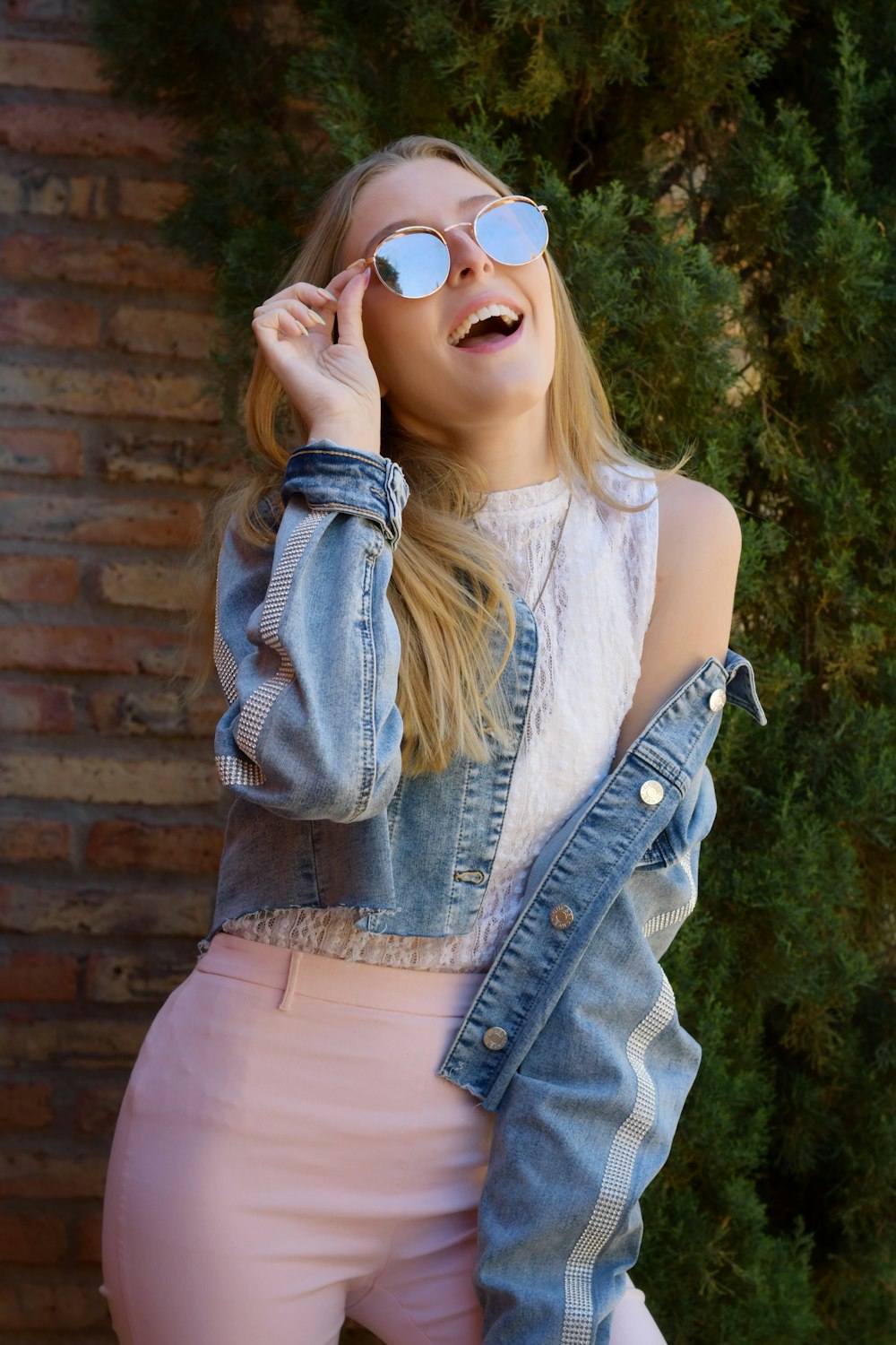 woman in blue denim jacket wearing white framed sunglasses