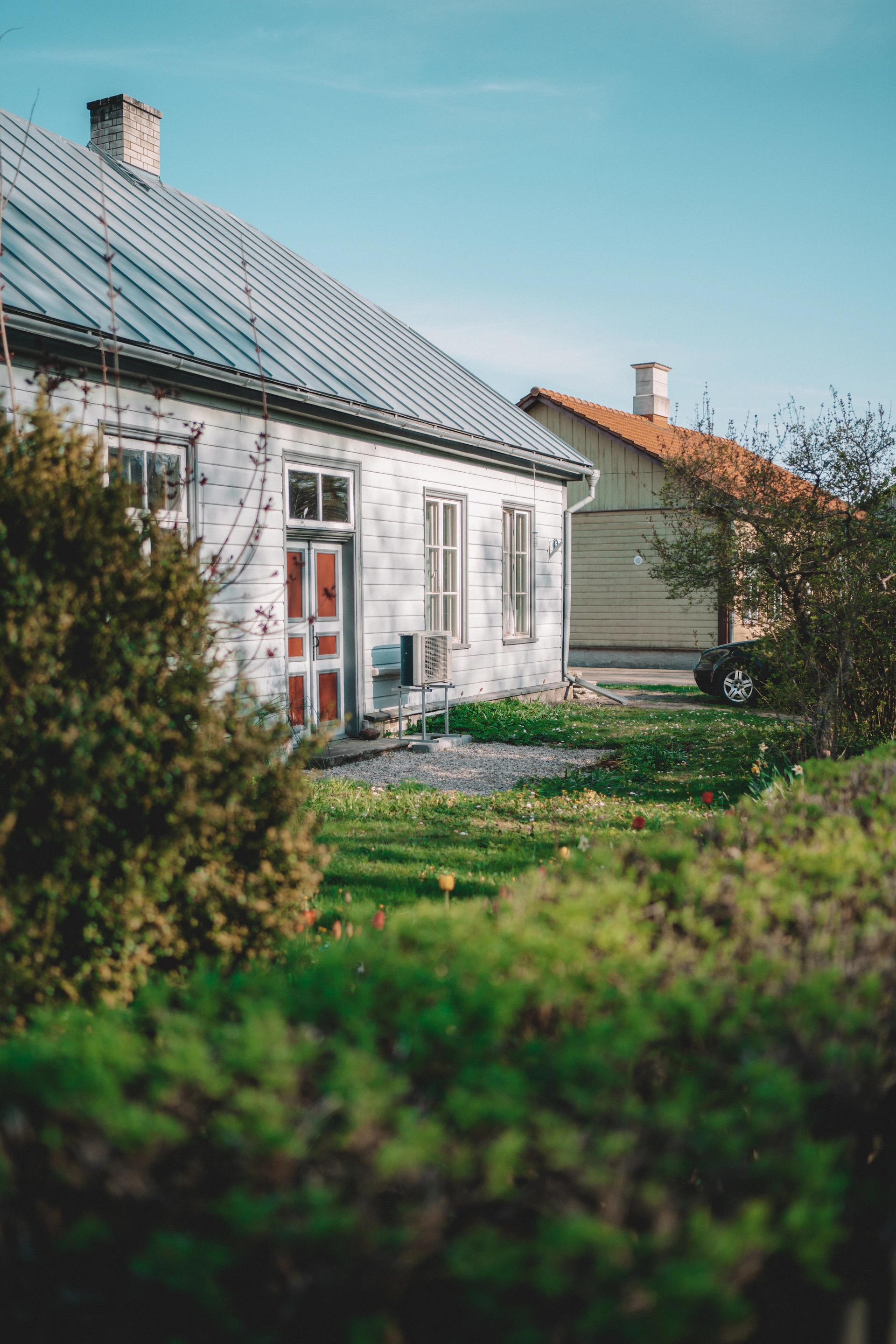 white and brown house near green grass field during daytime